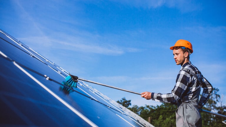 Technicien nettoyant un panneaux solaire sur une toiture dans le département de la Creuse