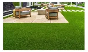 Modern backyard patio with high-quality artificial grass turf and luxury outdoor lounge furniture.