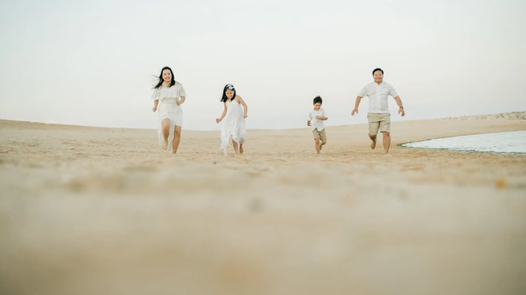 Family running together along the beach at The Apurva Kempinski Bali