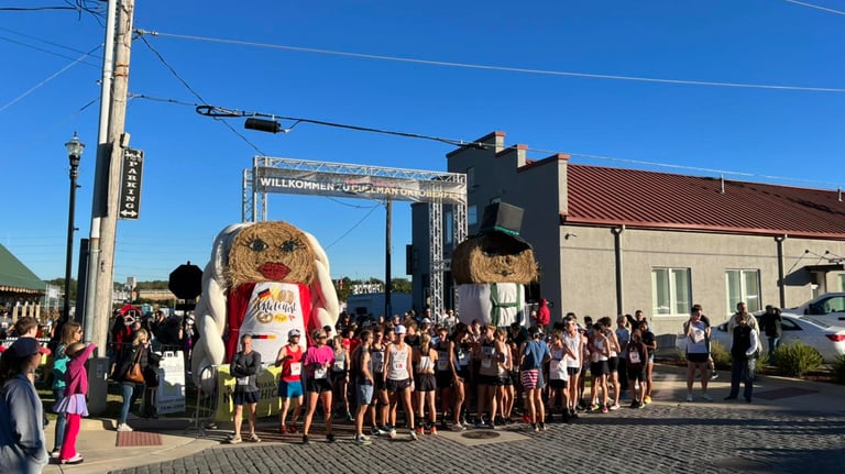 A photo of runners lined up for the start of the Cullman Oktoberfest with a bavarian backdrop