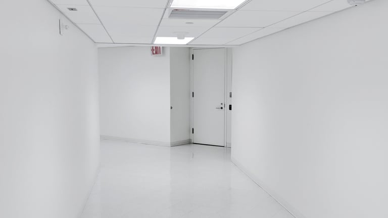a hallway with a door leading to a white room