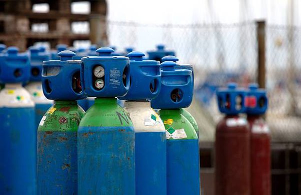 a row of gas bottles with gas cylinders