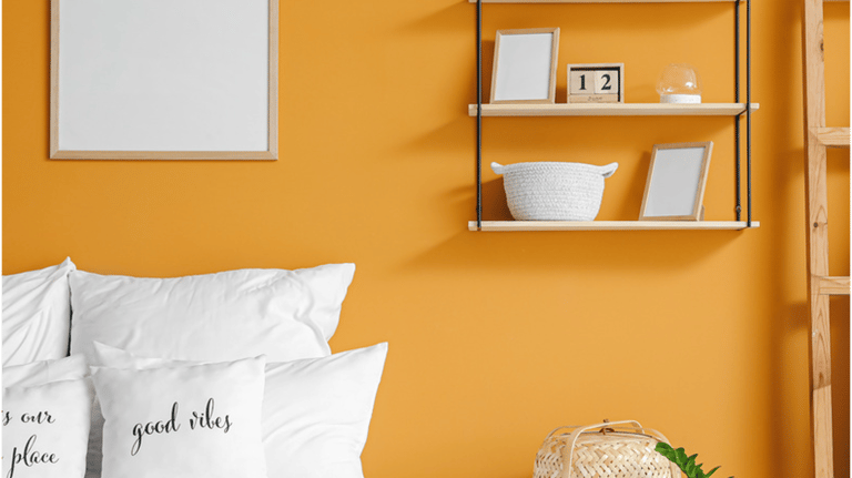 Modern bedroom with yellow walls, white bedding, and minimalist wall shelves with home decor.