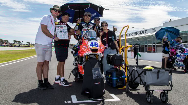 a group of people standing around a motorcycle