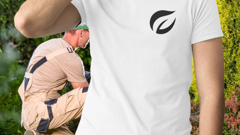 Un homme portant un t-shirt blanc avec un logo de feuille tout en aménageant l'extérieur.
