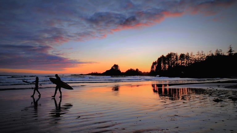 a couple of surfers on the beach at Tofino