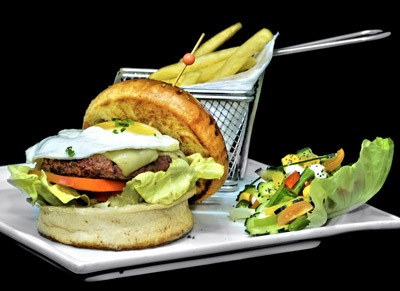 un burger avec une salade en accompagnement