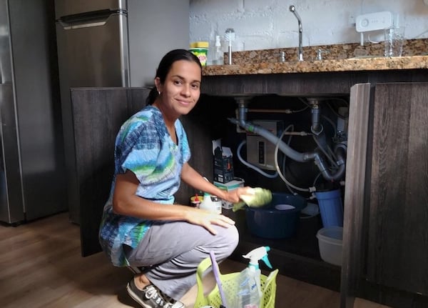 a woman in a blue shirt is cleaning a kitchen