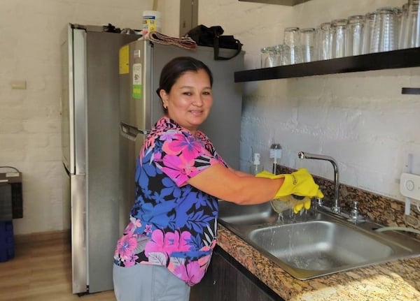 a woman in a blue shirt is cleaning a kitchen
