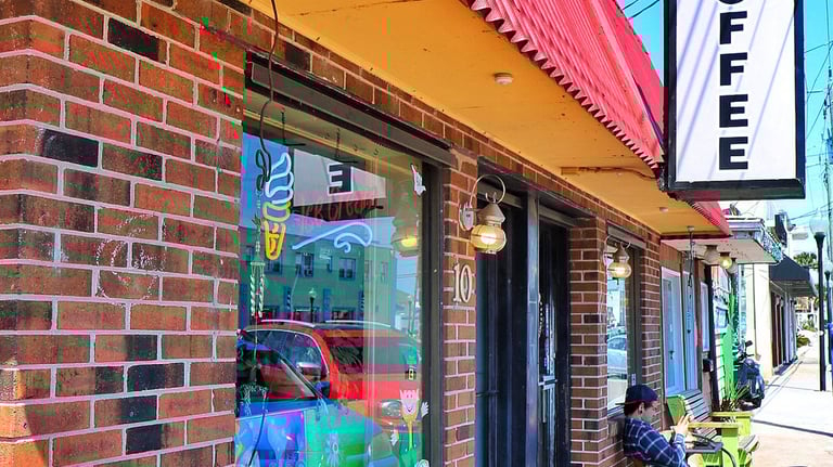 Majik Beanz Espresso coffee shop with brick exterior and outdoor sidewalk seating.