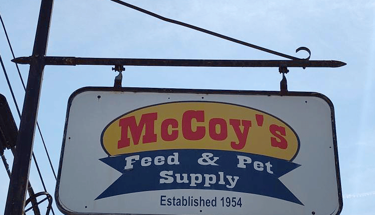 Vintage hanging sign for McCoy's Feed & Pet Supply established in 1954.