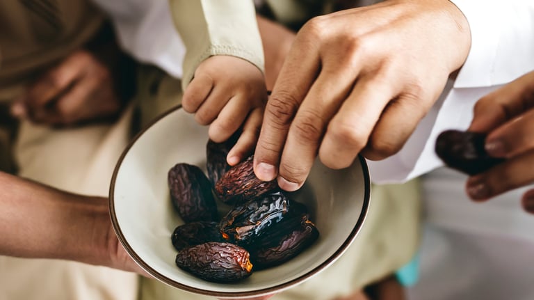 a man holding a bowl of dates in his hands