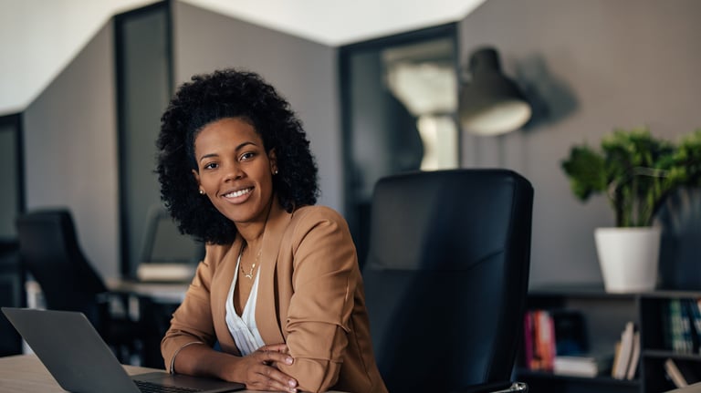 a woman sitting at a desk with a laptop