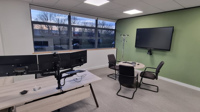 Office AV setup in Milton Keynes: Wall-mounted TV, conference camera, and integrated desk tech.