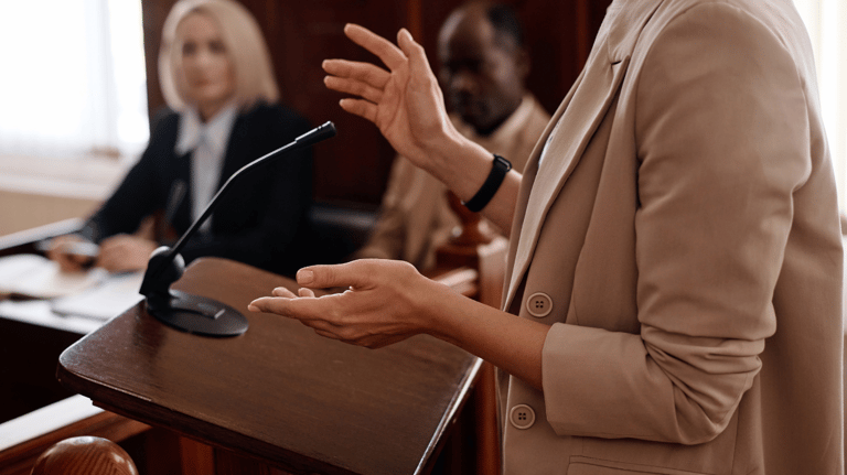 a woman in a suit and tie is speaking into a microphone