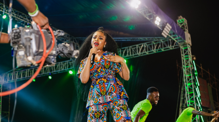 a woman sing on stage at a concert