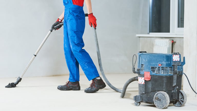 After building cleaning. a man in overalls and overalls cleaning a floor