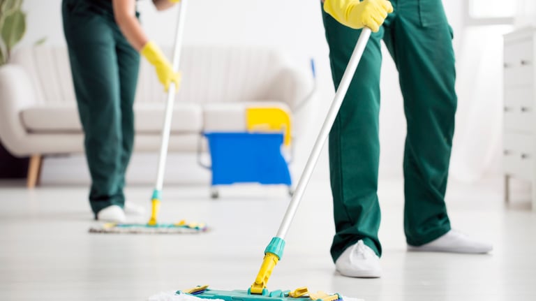 end of tenancy. a man and woman cleaning a floor with a mop