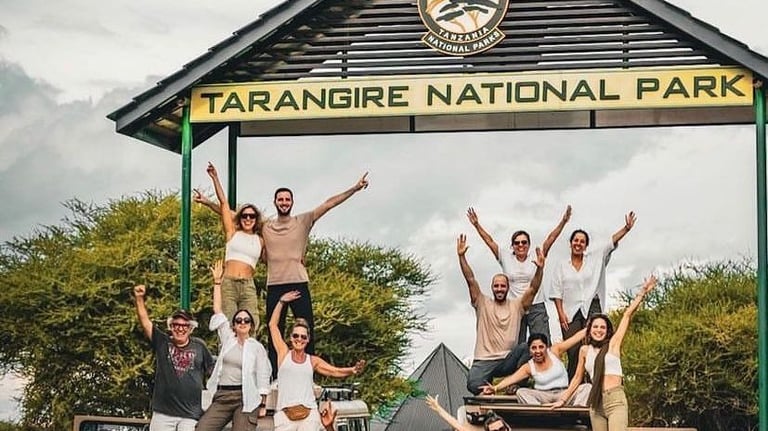 Group photo of tourists at the main entrance of Tarangire National Park in Tanzania before starting a safari adventure