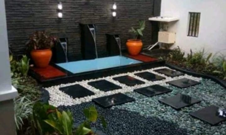 Dekorasi taman dan kolam renang yang cantik lengkap denga air mancurnya dan guci di kanan kiri nya.