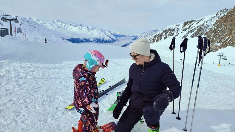 a woman and a child are standing in the snow