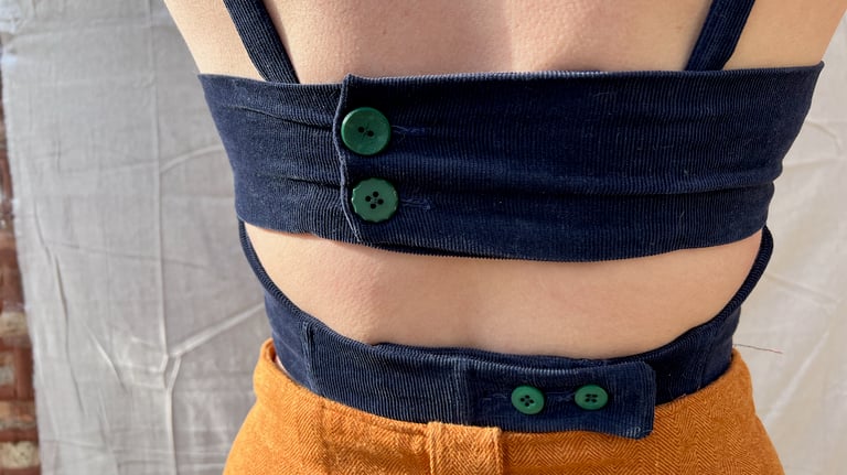 The back of a navy corduroy bustier fastened with green buttons