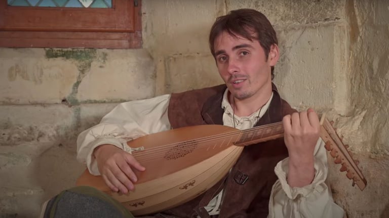a man in a vest playing a musical instrument