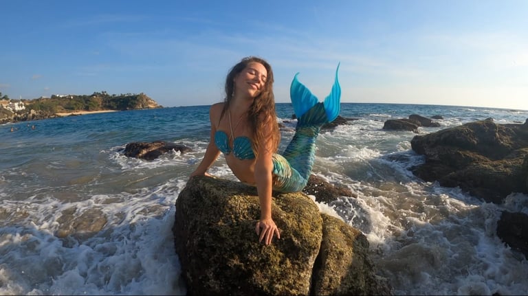 mermaid enjoying the sunlight on a rock, surrounded by the water of the ocean.