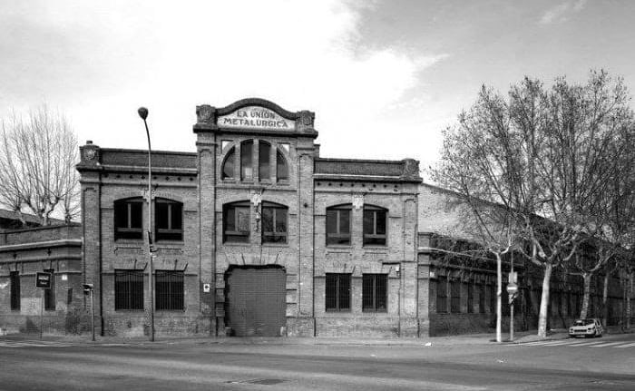 Vintage black and white photo of the industrial La Union Metalurgica brick building in Barcelona.