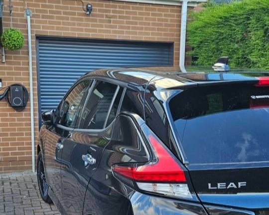 Nissan Leaf parked on a drive in Chesterfield with a newly installed EV charger on the house wall
