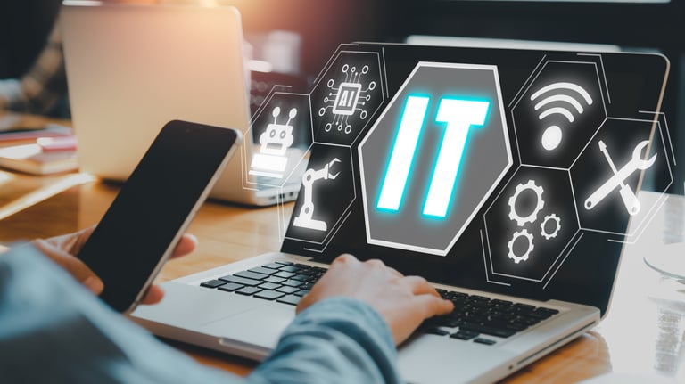 a person sitting at a laptop computer with a laptop and a phone