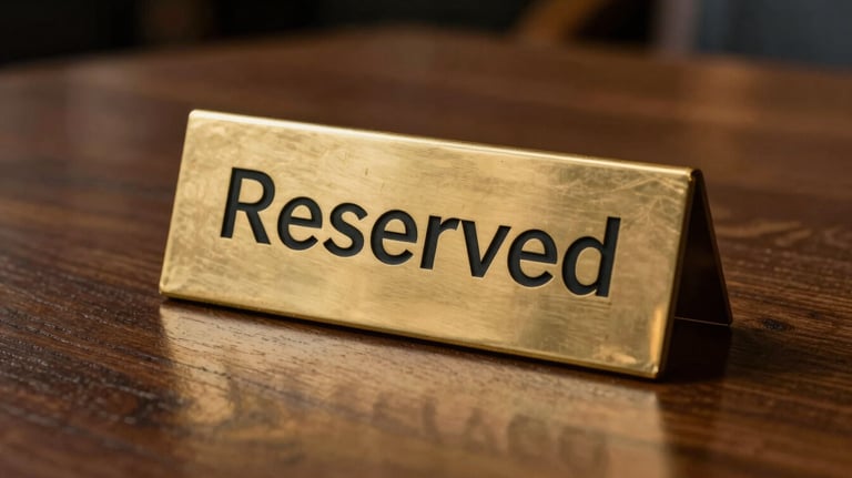 An artistic shot of a 'Reserved' sign made of polished brass on a dark wood table in an upscale restaurant. Minimalist and professional.