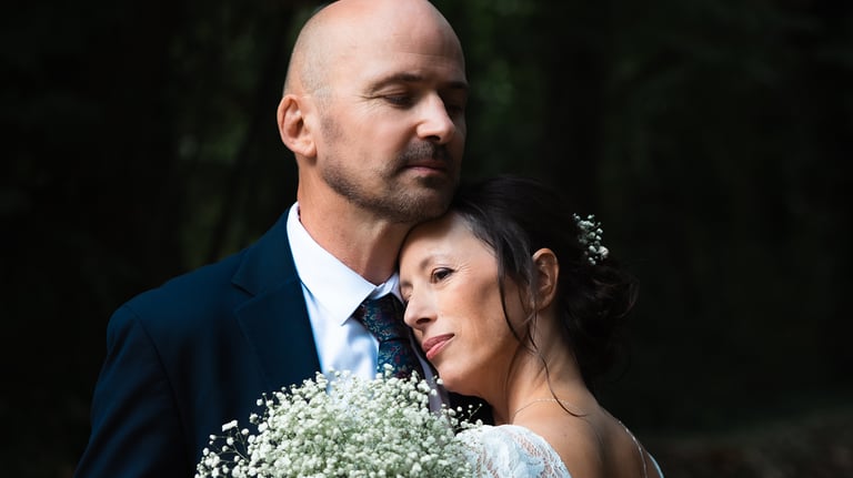 couple de mariés qui se prennent dans les bras en extérieur