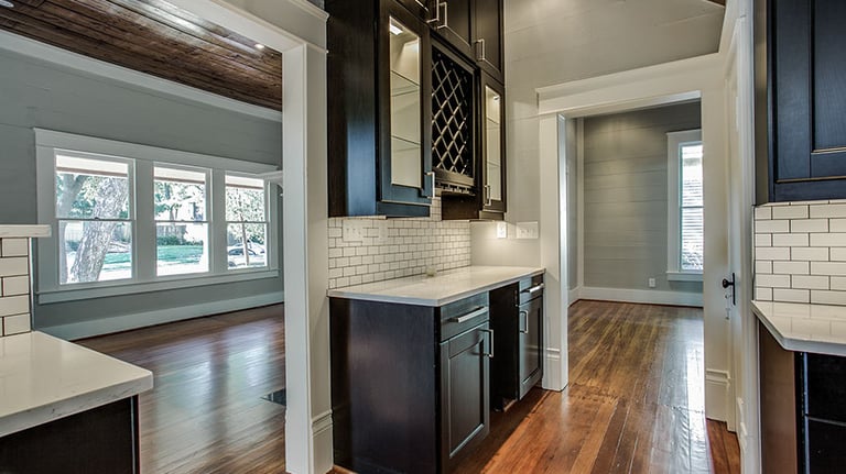 Home interior featuring dark wood cabinets, white subway tile backsplash, and hardwood floors.