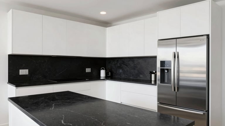 A wide shot of a modern Miami kitchen with white cabinetry, black stone countertops, and sleek stainless steel integrated appliances, bright and clean photography.