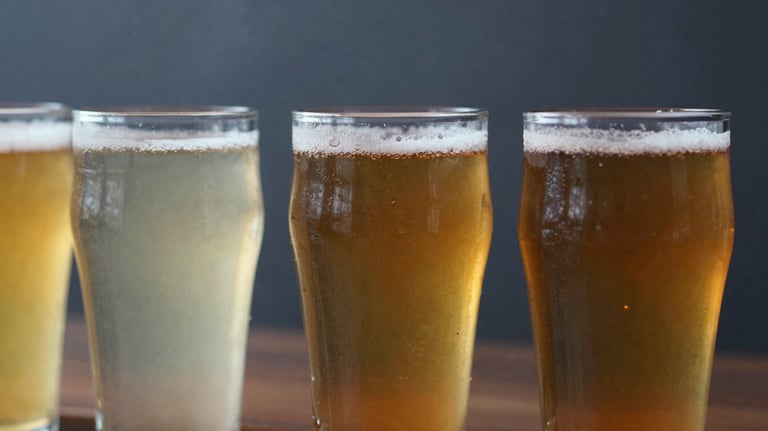 Close up of a beer flight with three different colors of beer in small glasses, mist grey and dark slate industrial background.
