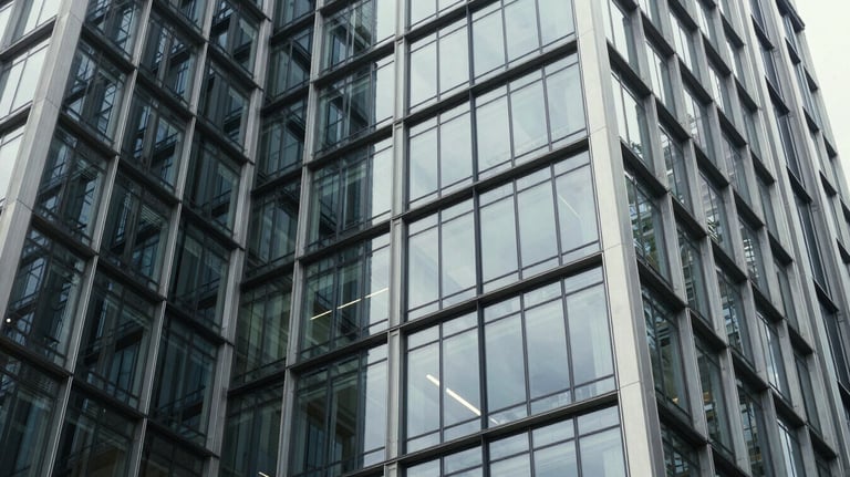 Detail shot of architectural steel and glass in a luxury corporate headquarters, representing strength and transparency. Global / High-end corporate.