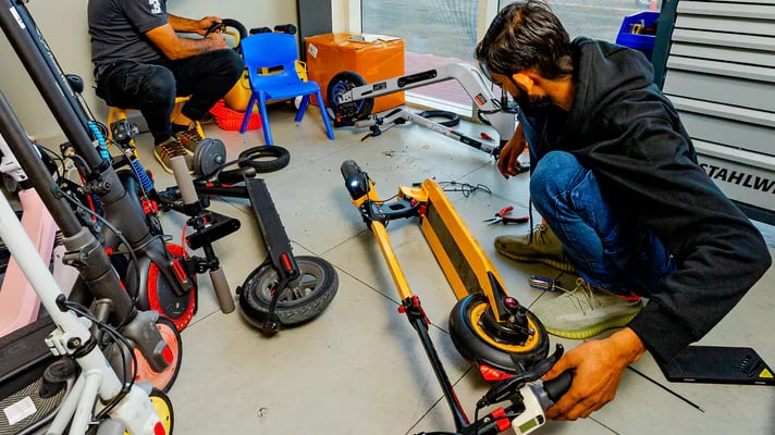 a man sitting on a scooter in a garage