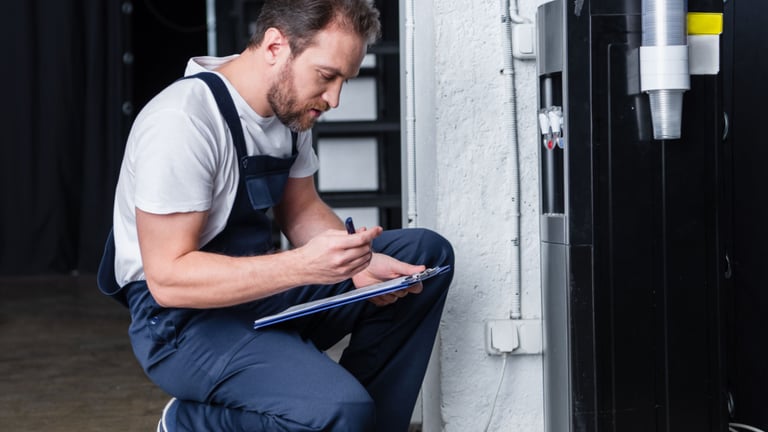 a man in overalls and overalls sitting on a stool