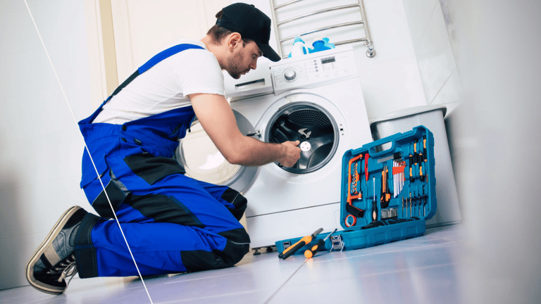 a man in overalls and overalls working on a washing machine