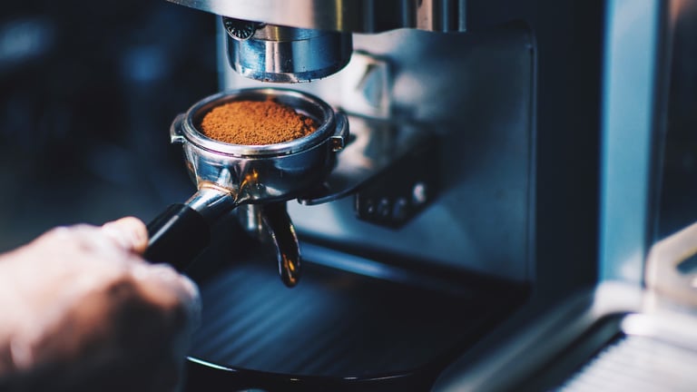 a person is making a coffee in a coffee machine