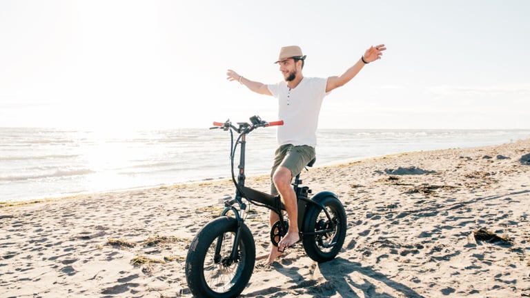 a man riding a bike on a beach