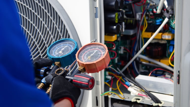 a man in a blue shirt and gloves holding a gauge