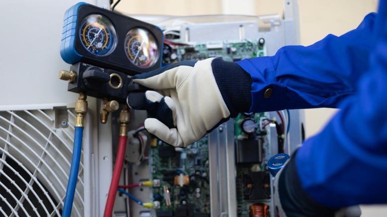 a person in a blue jacket and gloves holding a hose and a hose