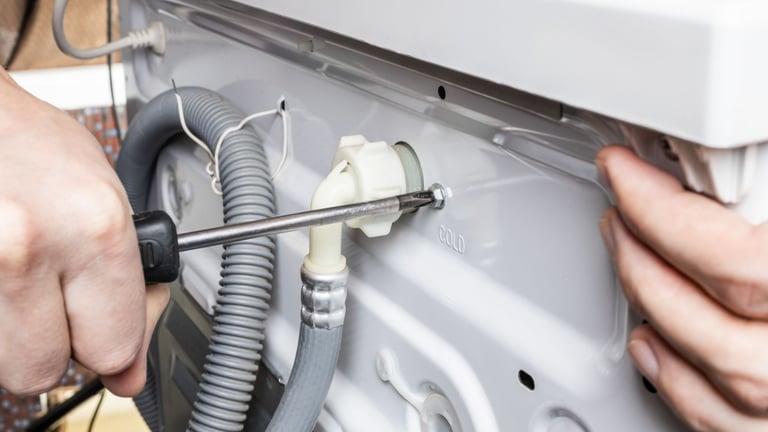 a person is fixing a dishwasher in a kitchen