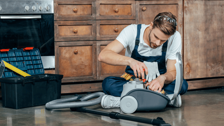 a man in overalls and overalls is cleaning a vacuum