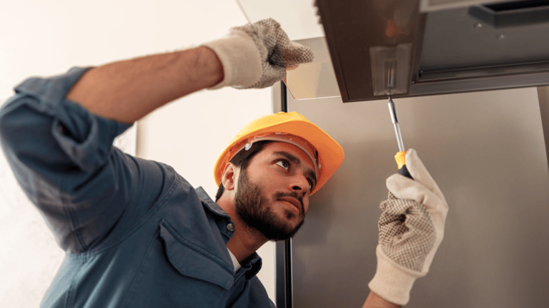 a man in a hard hat and gloves is holding a knife and a knife in