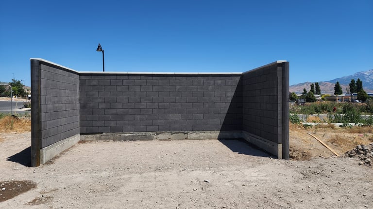 Charcoal colored CMU trash enclosure with precast concrete cap