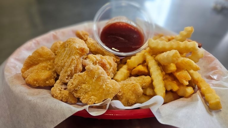 Crispy fried chicken bites and crinkle cut fries with BBQ dipping sauce at Captain's Galley