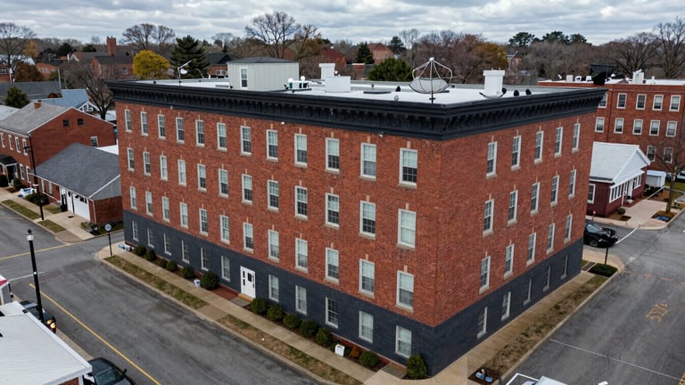 Overhead satellite view of 10 Burke Ave, Rowley, MA, showing the building and surrounding streets, crisp overcast daylight, high detail.